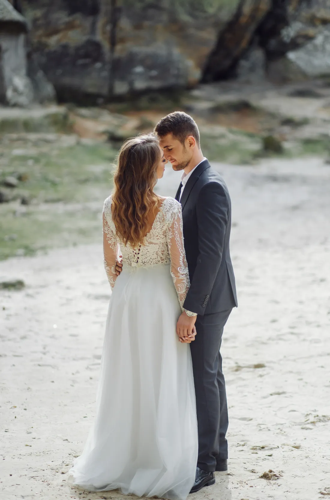 Casal abraçado numa trilha de areia clara